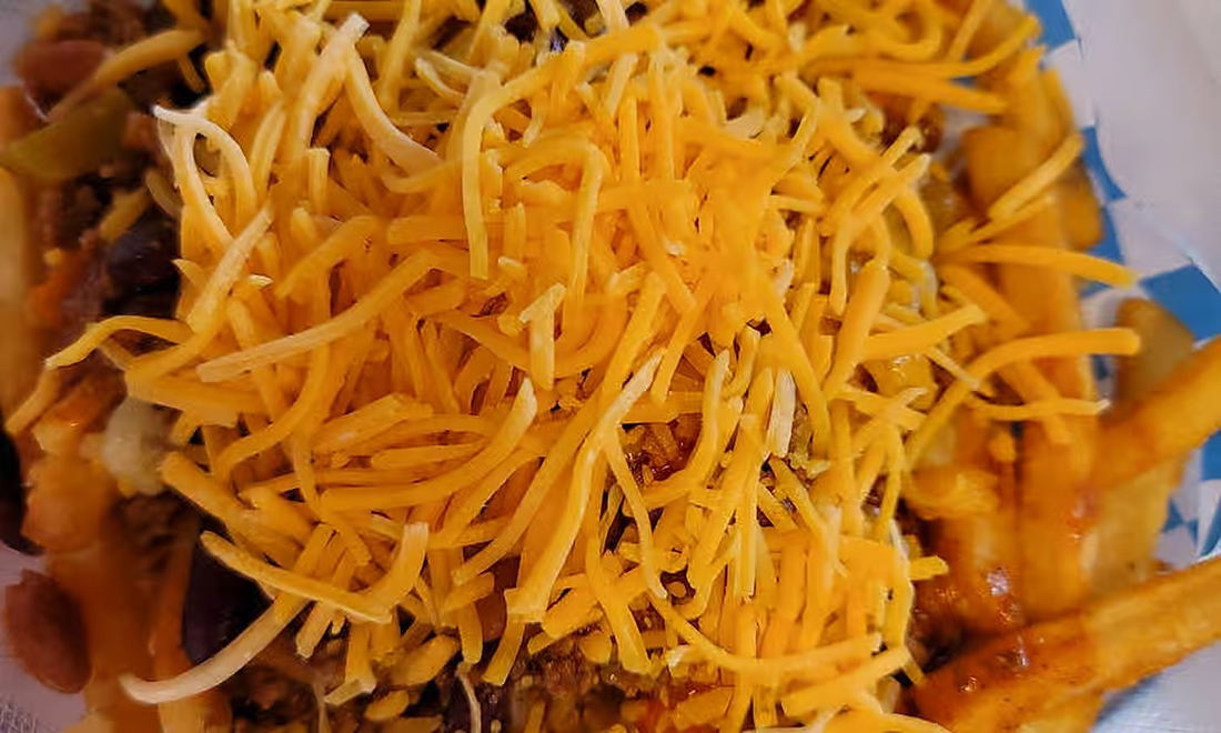 Fries smothered in chili and buried under shredded cheddar cheese